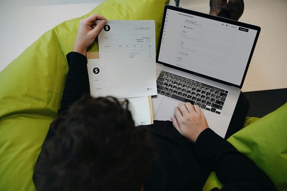 Person on a bean bag chair with a laptop, figuring out how to claim a tax rebate.