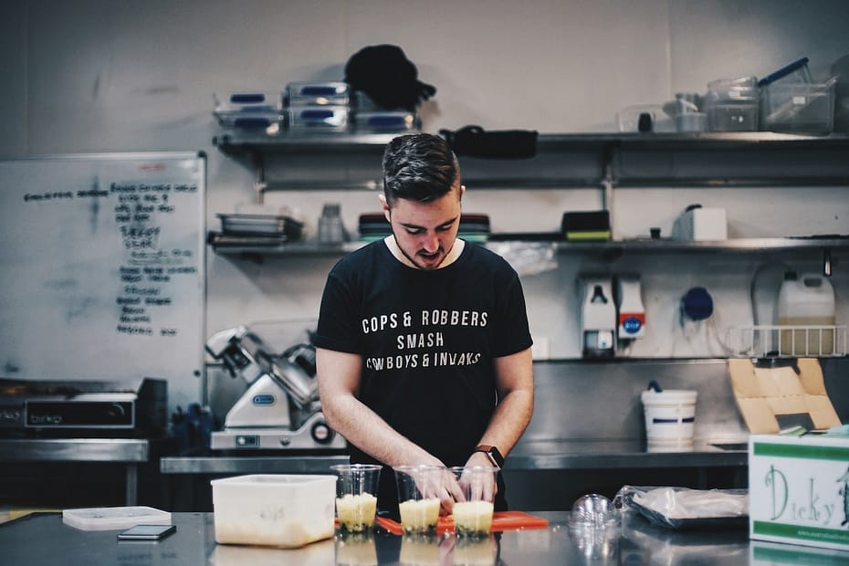 Man in a black shirt at his kitchen table, reviewing limited company tax deductible expenses.