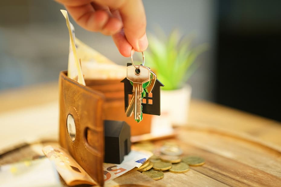 Close-up of a wallet and keys with house charm—reminding landlords about self assessment for property income.