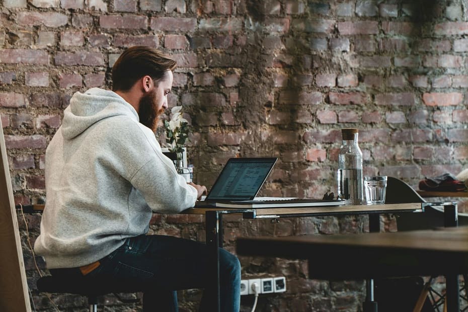 Seated man working on a laptop, reviewing split year treatment for a change in UK residence.