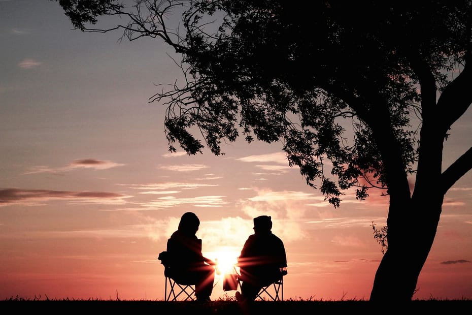 Two people sitting beneath a tree, reflecting retirement questions like is pension credit taxable.