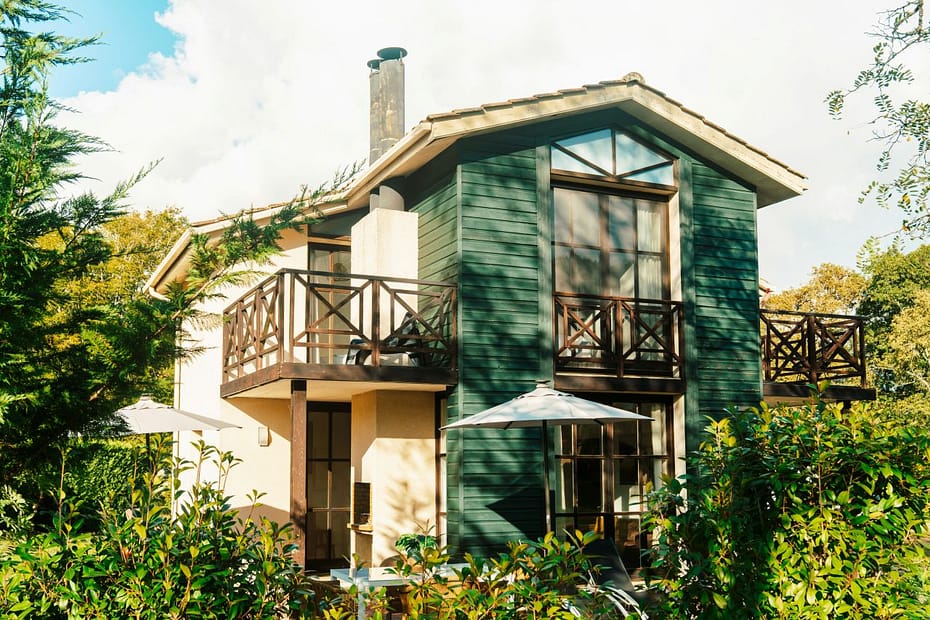 House among lush trees, illustrating property ownership and tax advice for landlords.