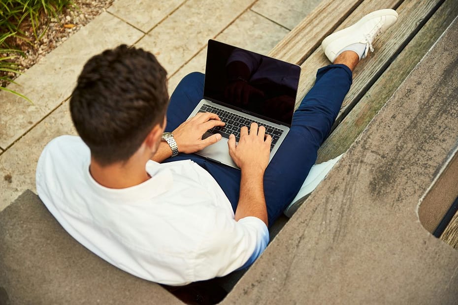 Young professional on a sofa with a laptop, reviewing tax allowances for the self employed.